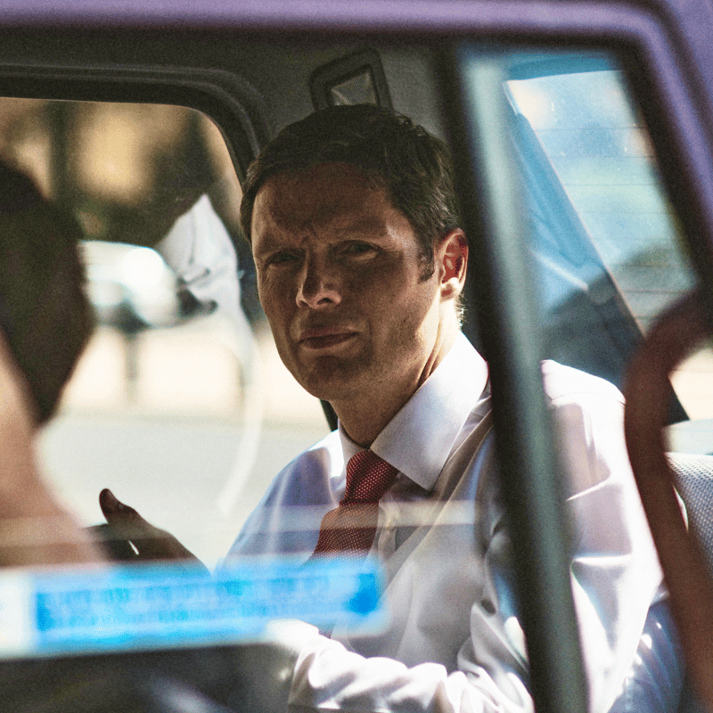 Business man working in the back of a car