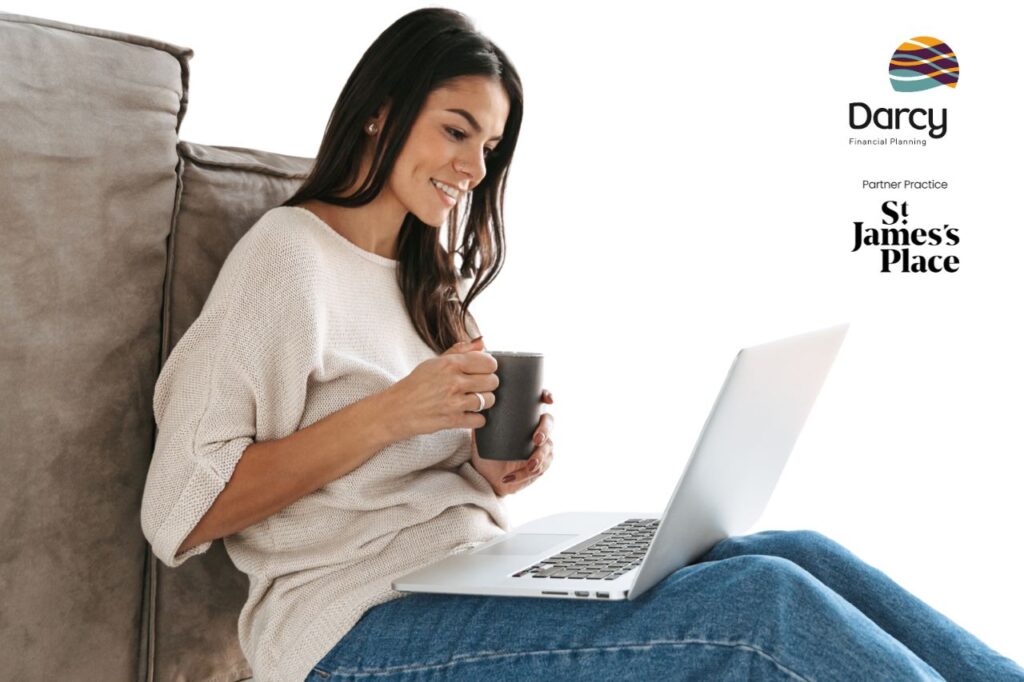 Woman sitting reading information on her laptop while drinking coffee.