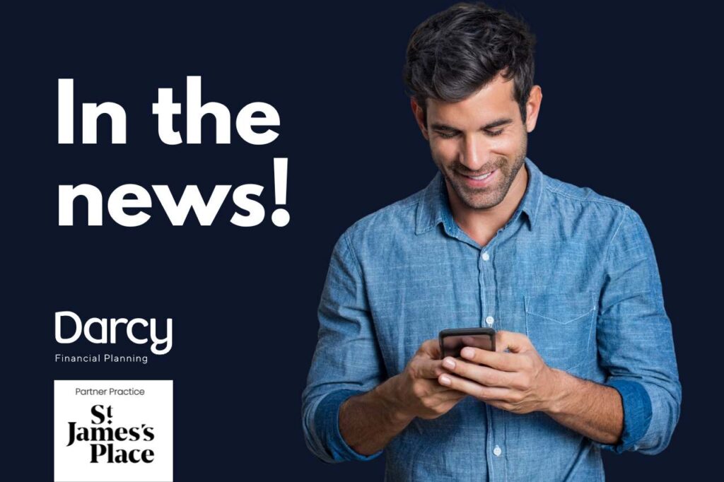 Image of a man in a blue shirt smiling while reading the news on his mobile phone