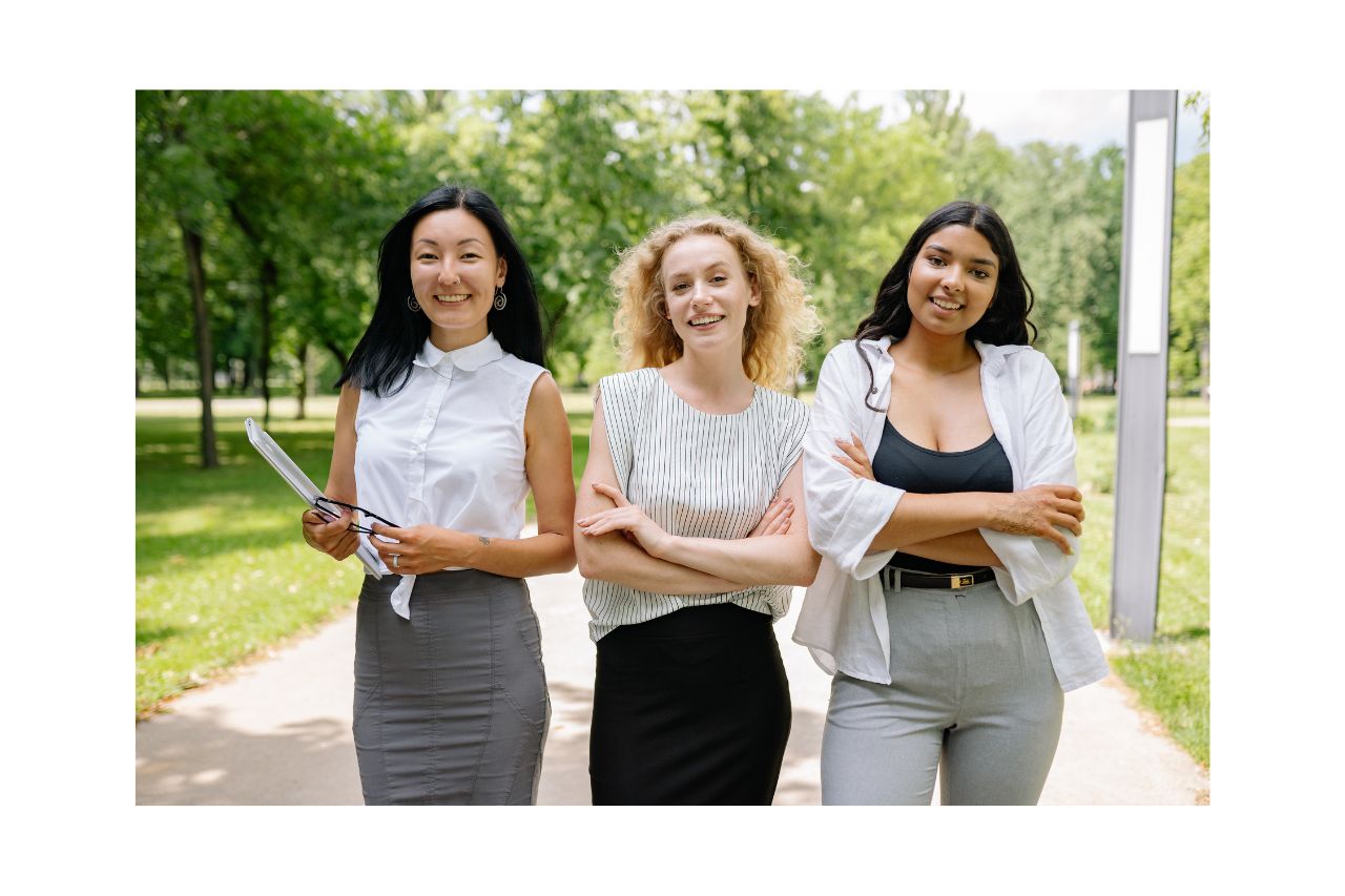 Three young women walking to a business meeting in the sunshine.